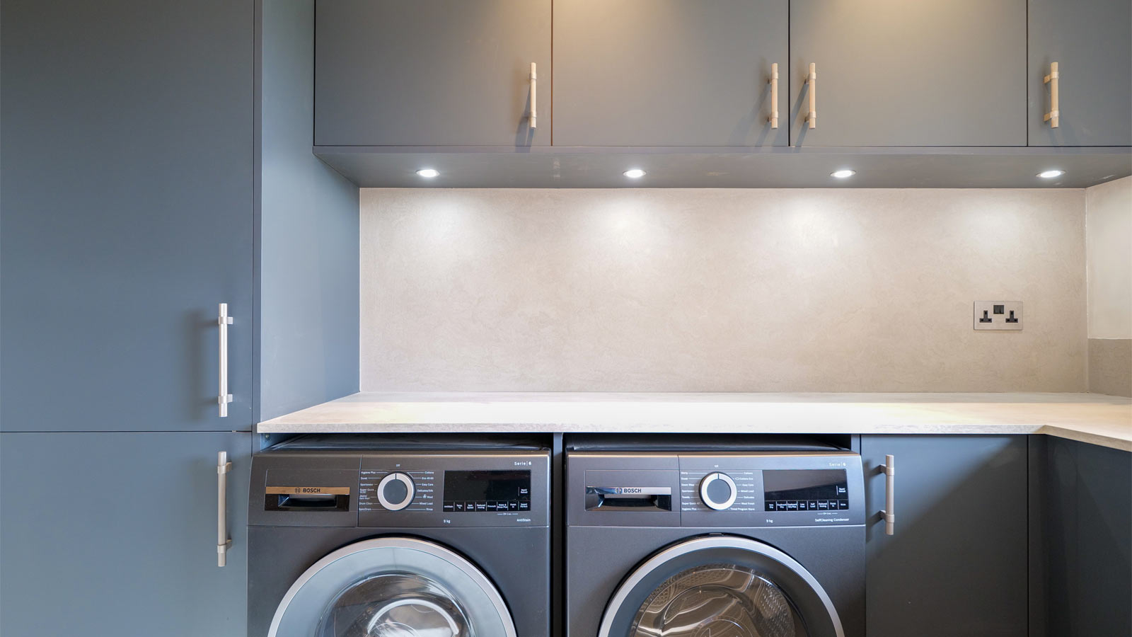 A modern unitlity room with grey cabinets for Grand Designs