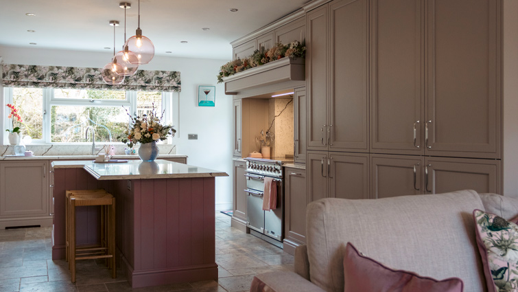 A grey in-frame kitchen with a pink kitchen island