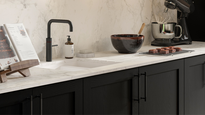 A black kitchen with a white countertop
