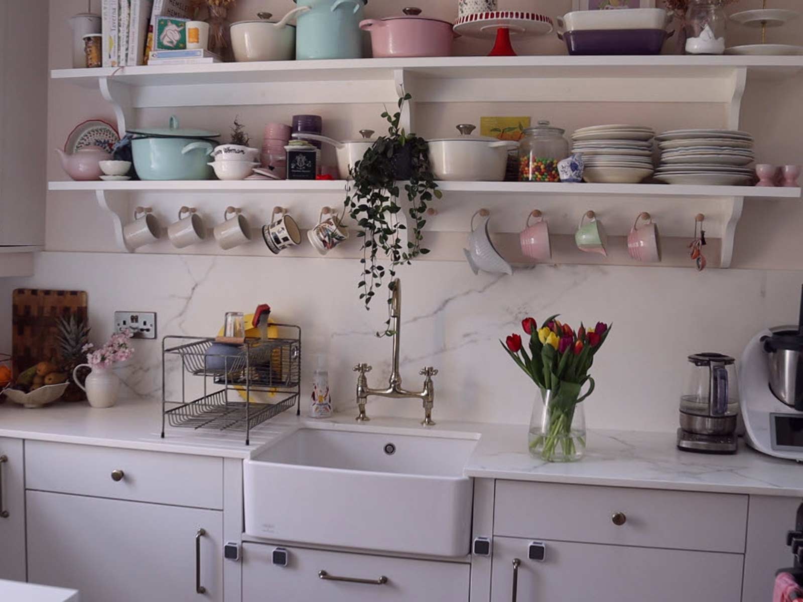 Maximalism décor featured in a marble and grey kitchen with a Belfast sink