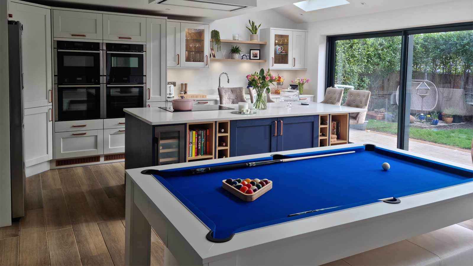 A dopamine kitchen with blue cabinets, a blue pool table and retro furniture