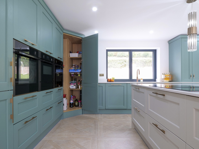 A kitchen island extension space with green kitchen cabinets