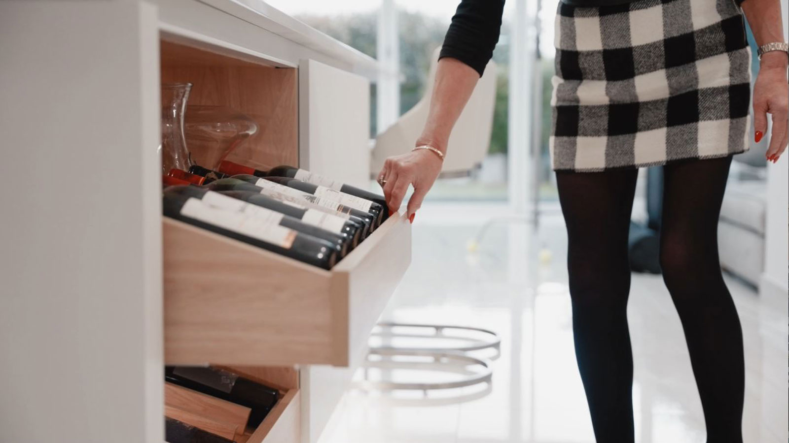 A set of doorless kitchen cabinet drawers containing wine drawer inserts