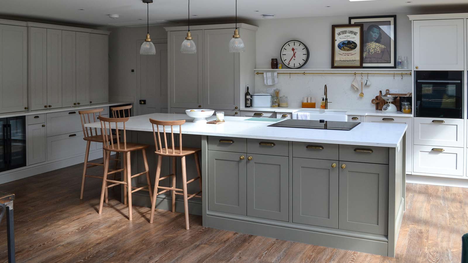 A large Nancy-Meyers-style kitchen with an island, stools and marble worktops