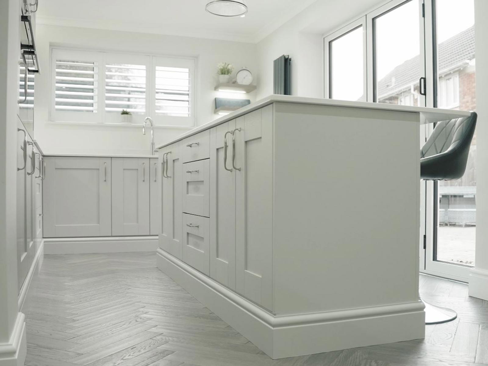 A light grey Shaker kitchen with a slim kitchen island