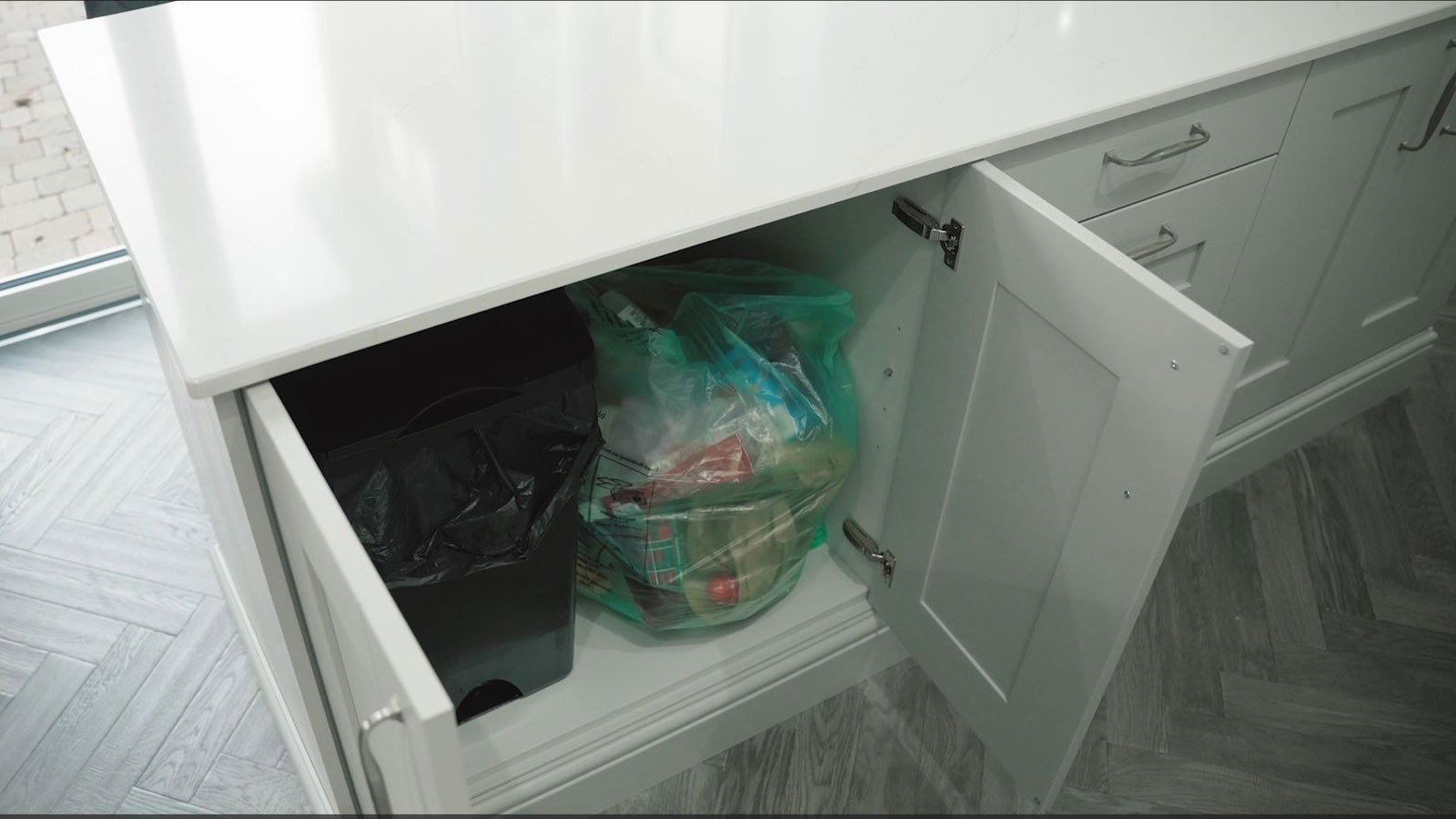 An under-counter kitchen storage idea containing hidden kitchen bins