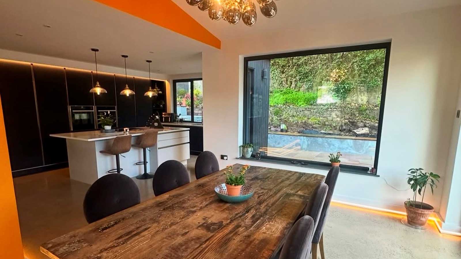 An open-plan kitchen with a wooden dining table